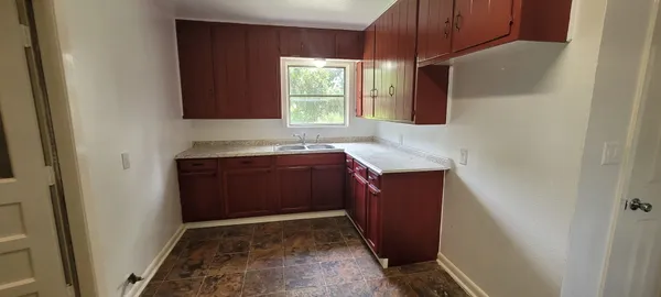 a kitchen with sink window and cabinets