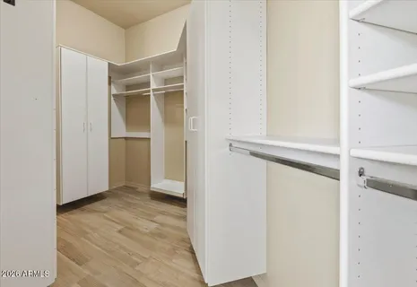 a view of walk in closet with empty racks