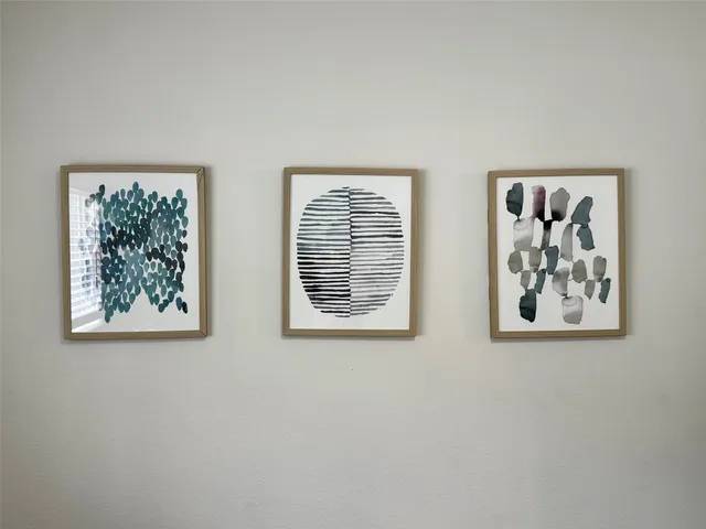 a view of room with window and painting on the wall