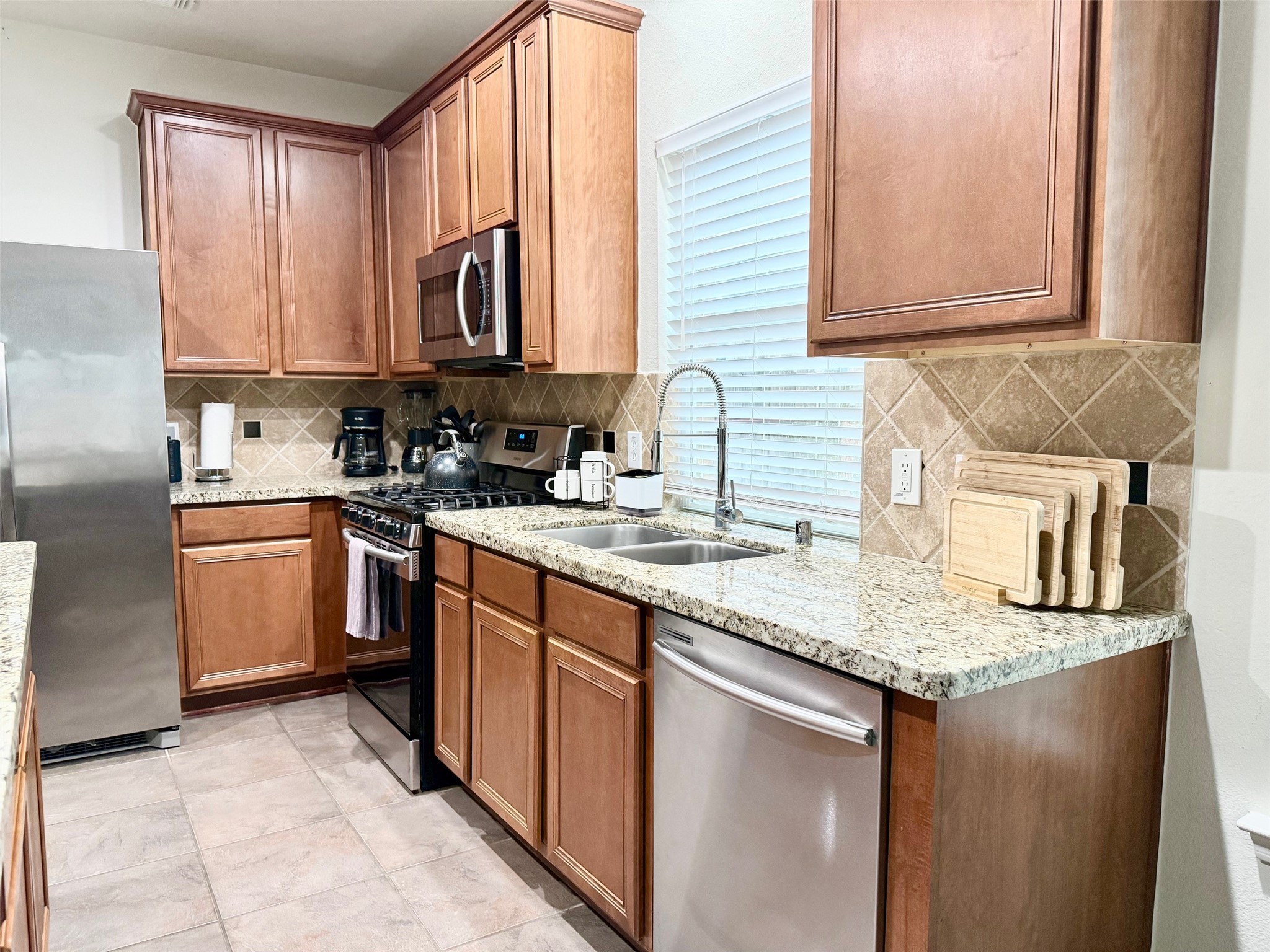 142 East Spindle Tree Circle The Woodlands, TX 77382 - Photo 25 of 37 a kitchen with stainless steel appliances granite countertop a sink stove and cabinets