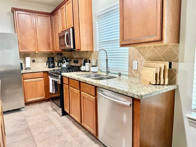 a kitchen with stainless steel appliances granite countertop a sink stove and cabinets