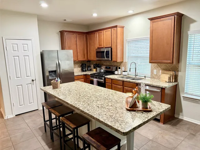 a kitchen with granite countertop a sink appliances and cabinets