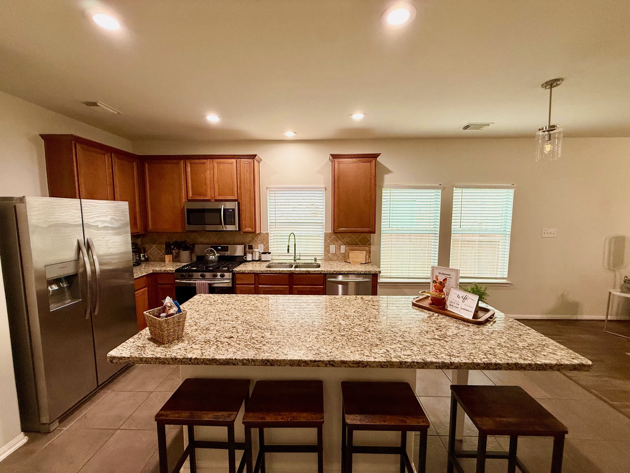 142 East Spindle Tree Circle The Woodlands, TX 77382 - Photo 3 of 37 a kitchen with granite countertop sink refrigerator and microwave