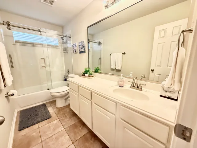a bathroom with a double vanity sink toilet mirror and shower