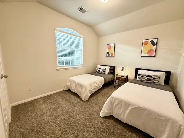 a bedroom with two beds and a window