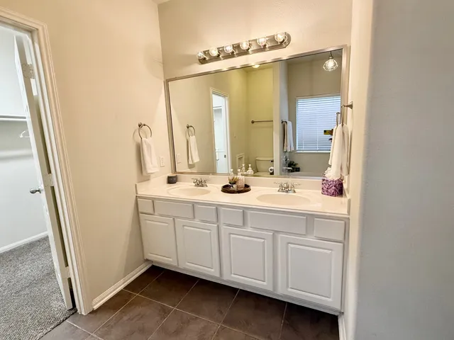a bathroom with a double vanity sink a mirror and a