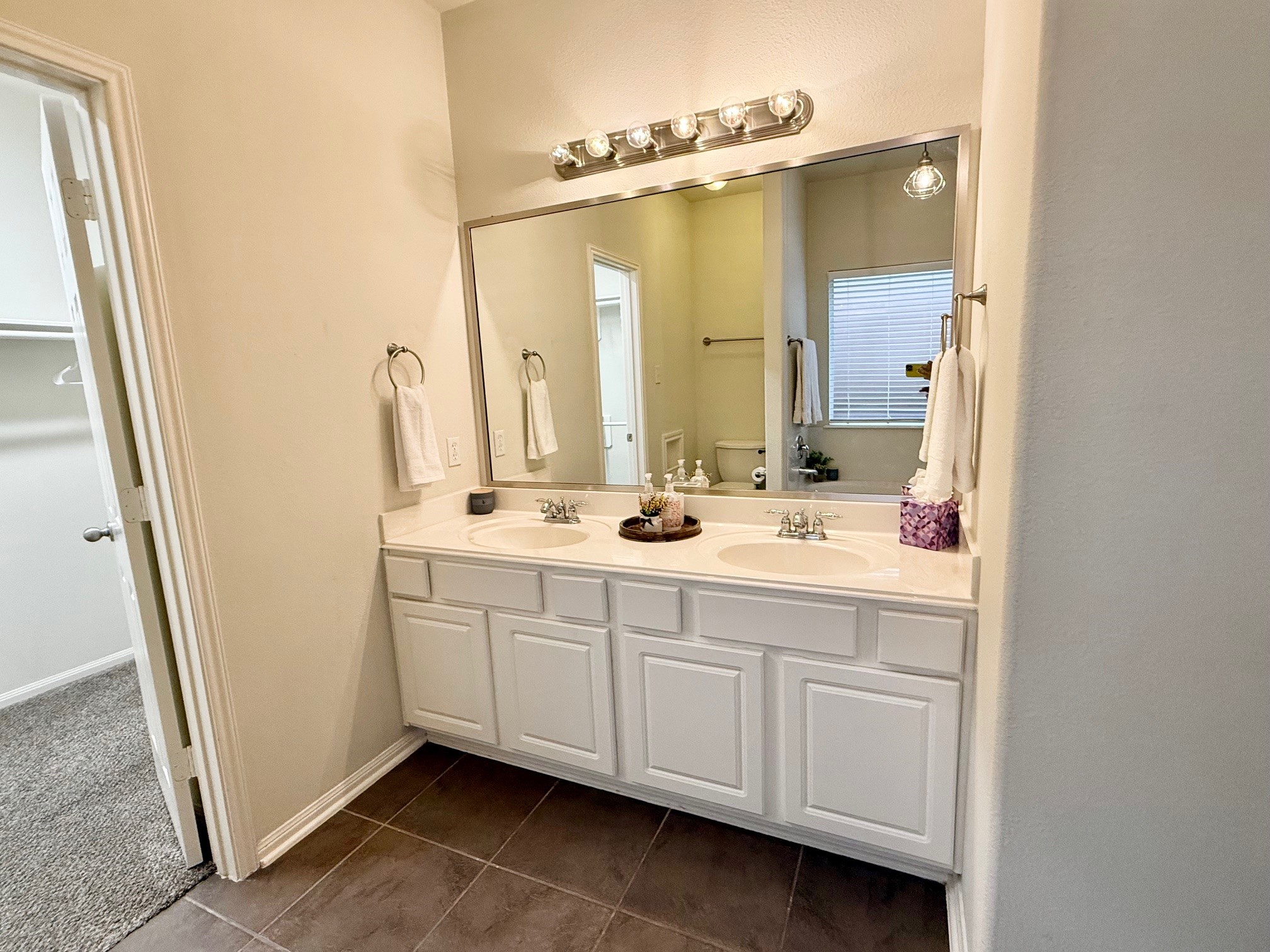 142 East Spindle Tree Circle The Woodlands, TX 77382 - Photo 9 of 37 a bathroom with a double vanity sink a mirror and a