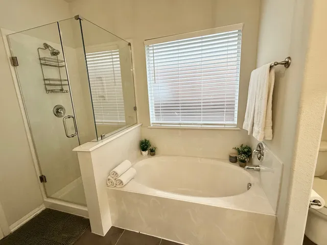 a white bath tub sitting next to a shower