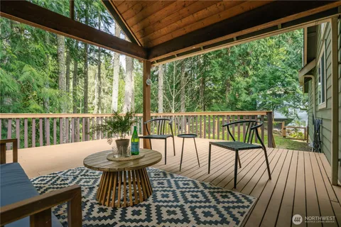 a view of a balcony with wooden floor and outdoor seating