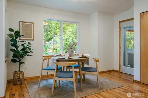 a view of a workspace room with wooden floor dining table and a window