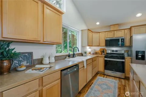 a kitchen with a sink a counter appliances and cabinets