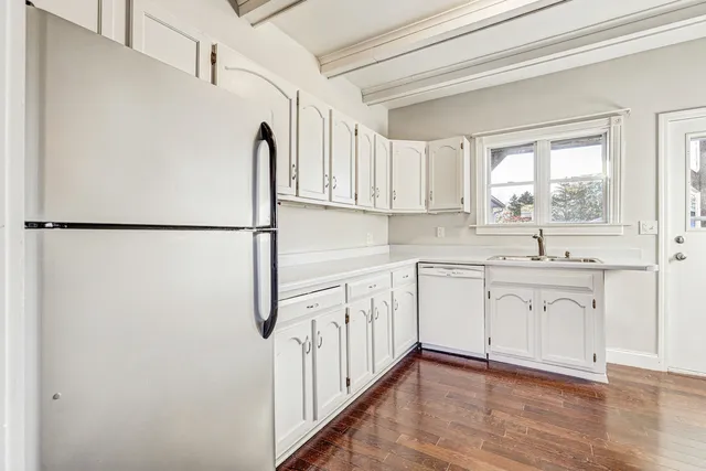 a kitchen with white cabinets and white appliances