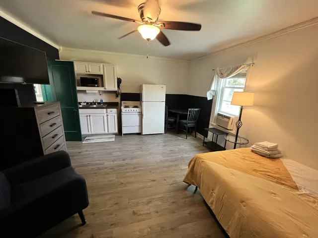 a spacious bedroom with a bed a couch and a flat screen tv