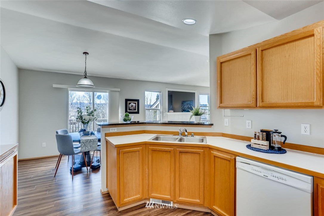 21022 25th Drive Southeast Bothell, WA 98021 - Photo 9 of 27 a kitchen with stainless steel appliances granite countertop a sink dishwasher and cabinets with wooden floor