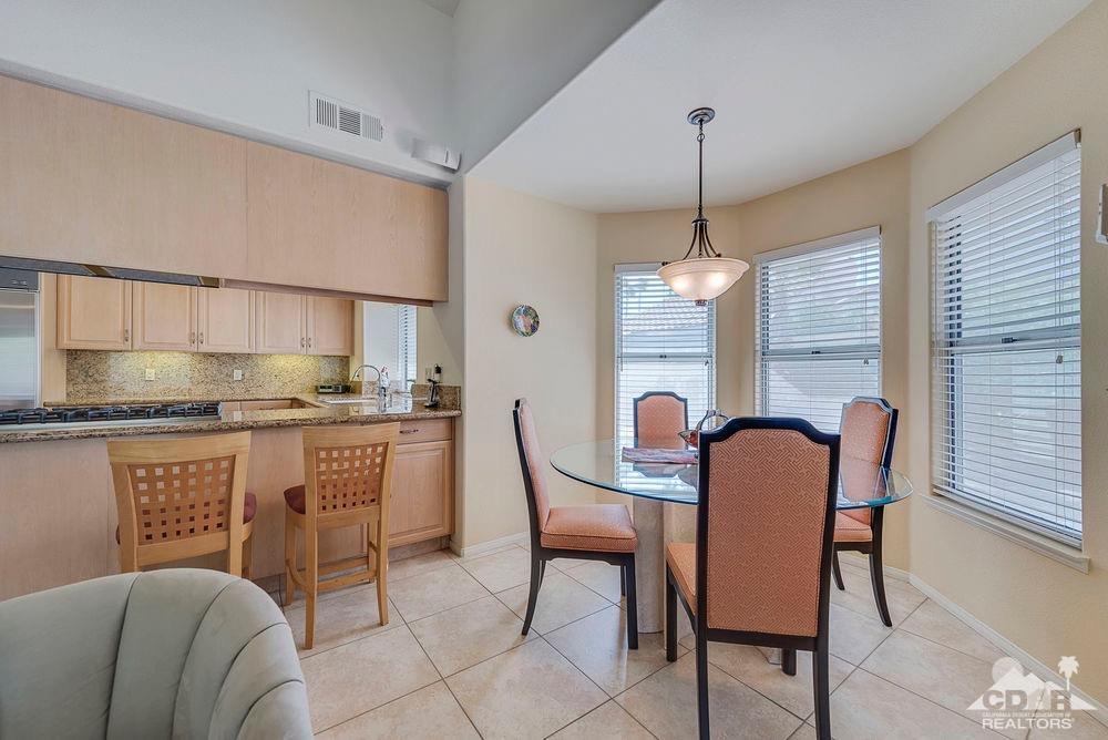 36725 Palmdale Road Rancho Mirage, CA 92270 - Photo 22 of 38 a dining room filled chandelier and kitchen view