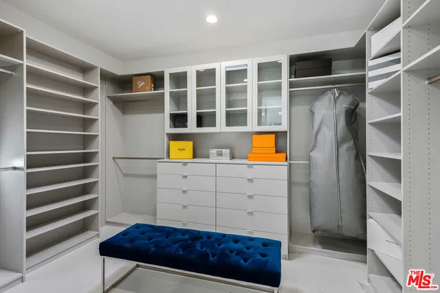 a view of walk in closet with clothes and shoes