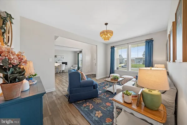 a living room with furniture and a dining table with wooden floor