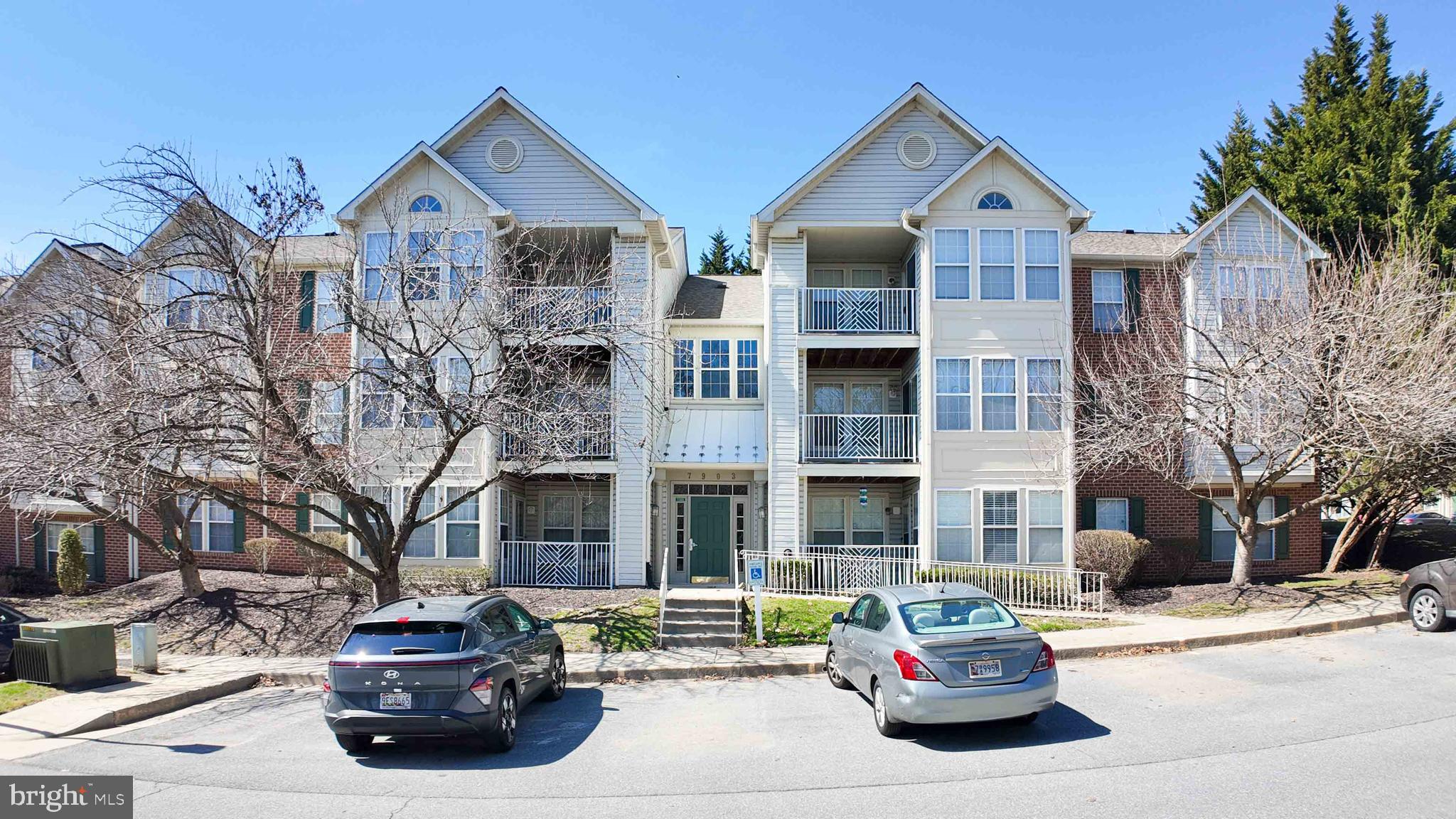 7903 Valley Manor Road, Unit 103 Owings Mills, MD 21117 - Photo 1 of 58 a car parked in front of a brick house with a small yard