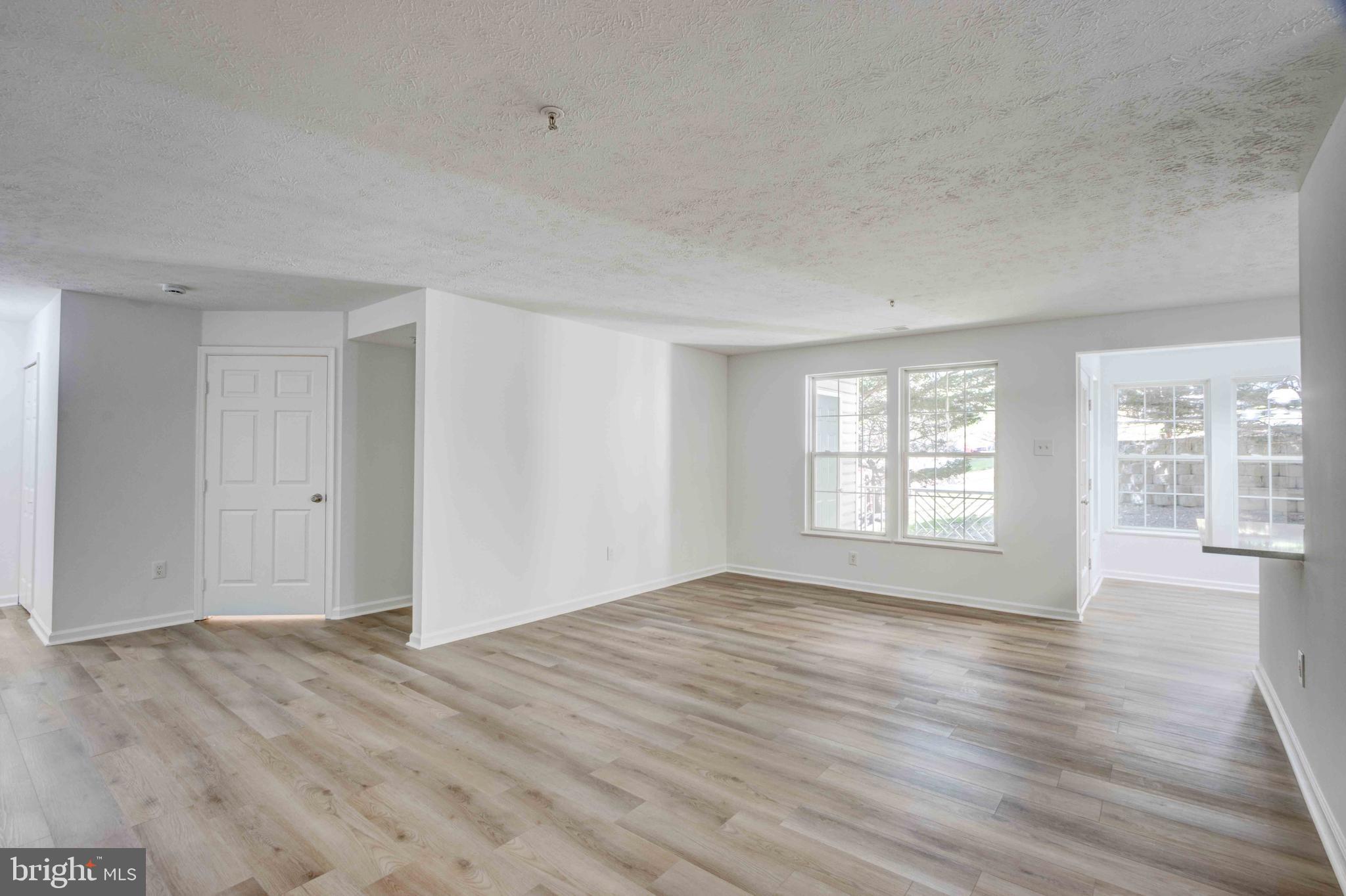 7903 Valley Manor Road, Unit 103 Owings Mills, MD 21117 - Photo 16 of 58 a view of empty room with wooden floor and fan