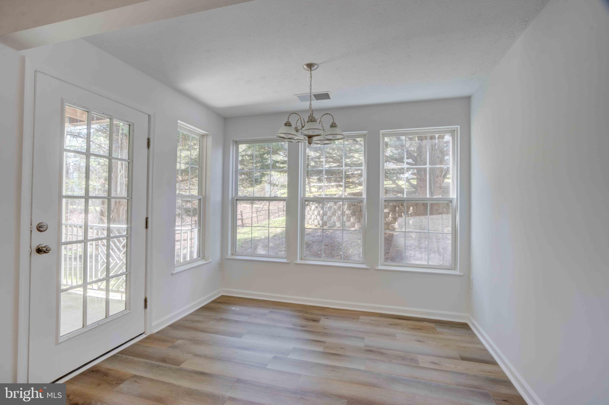 7903 Valley Manor Road, Unit 103 Owings Mills, MD 21117 - Photo 25 of 58 a view of an empty room with wooden floor and a window