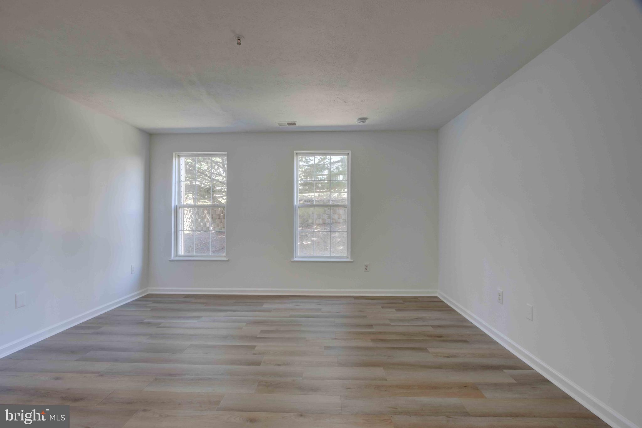7903 Valley Manor Road, Unit 103 Owings Mills, MD 21117 - Photo 27 of 58 wooden floor in an empty room with a window