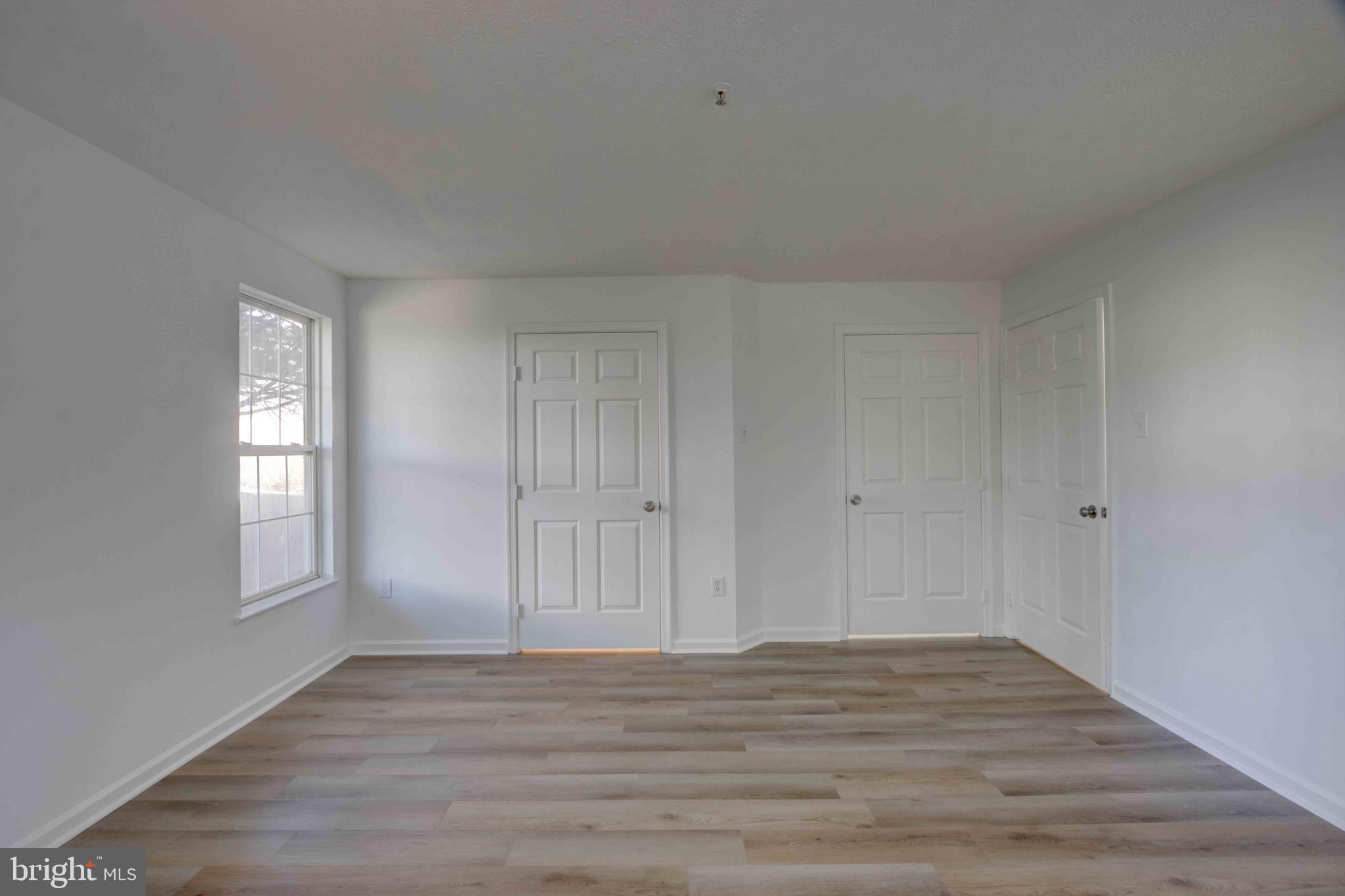 7903 Valley Manor Road, Unit 103 Owings Mills, MD 21117 - Photo 28 of 58 a view of empty room with window and wooden floor