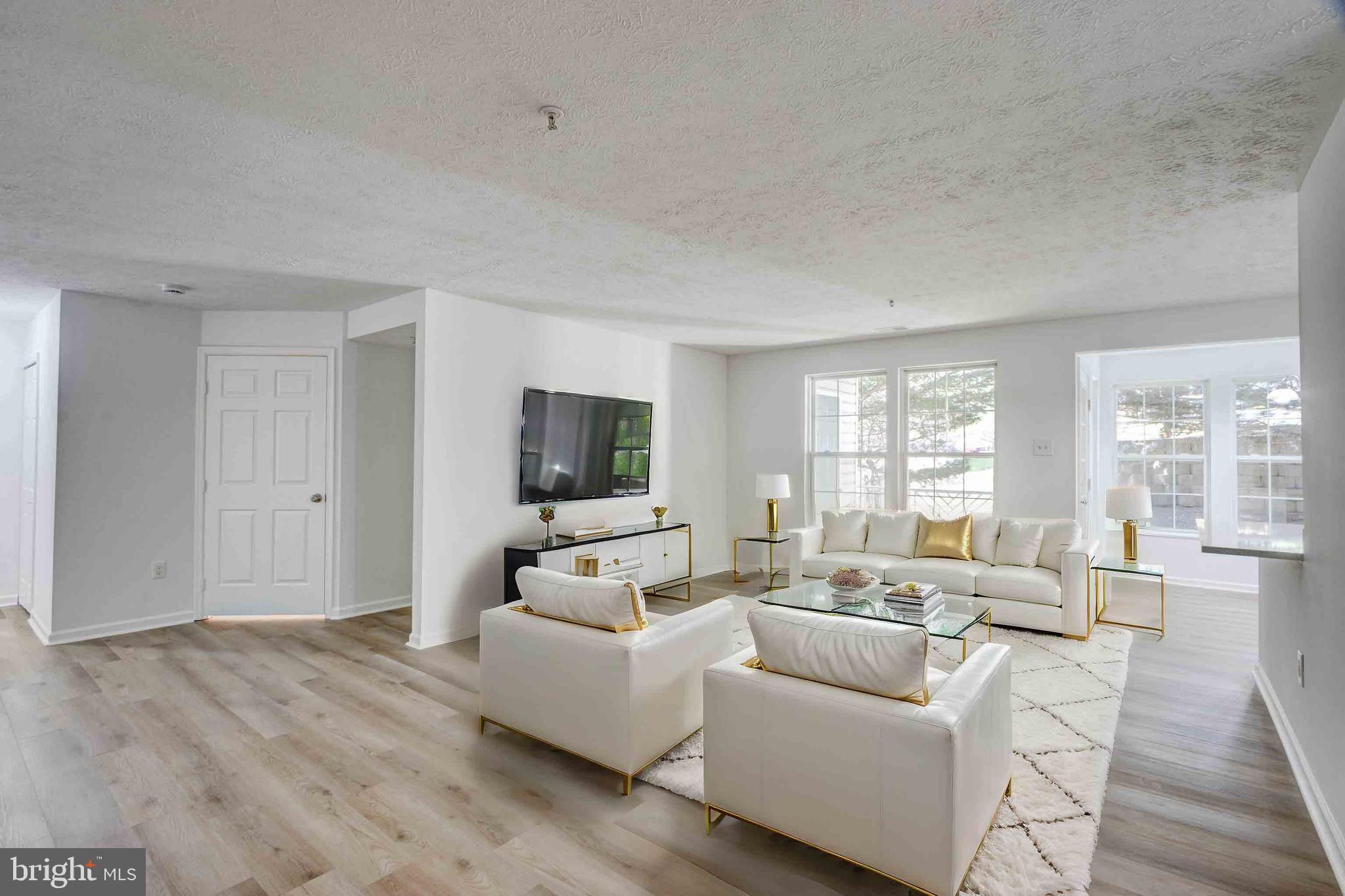 7903 Valley Manor Road, Unit 103 Owings Mills, MD 21117 - Photo 40 of 58 a living room with furniture and a flat screen tv