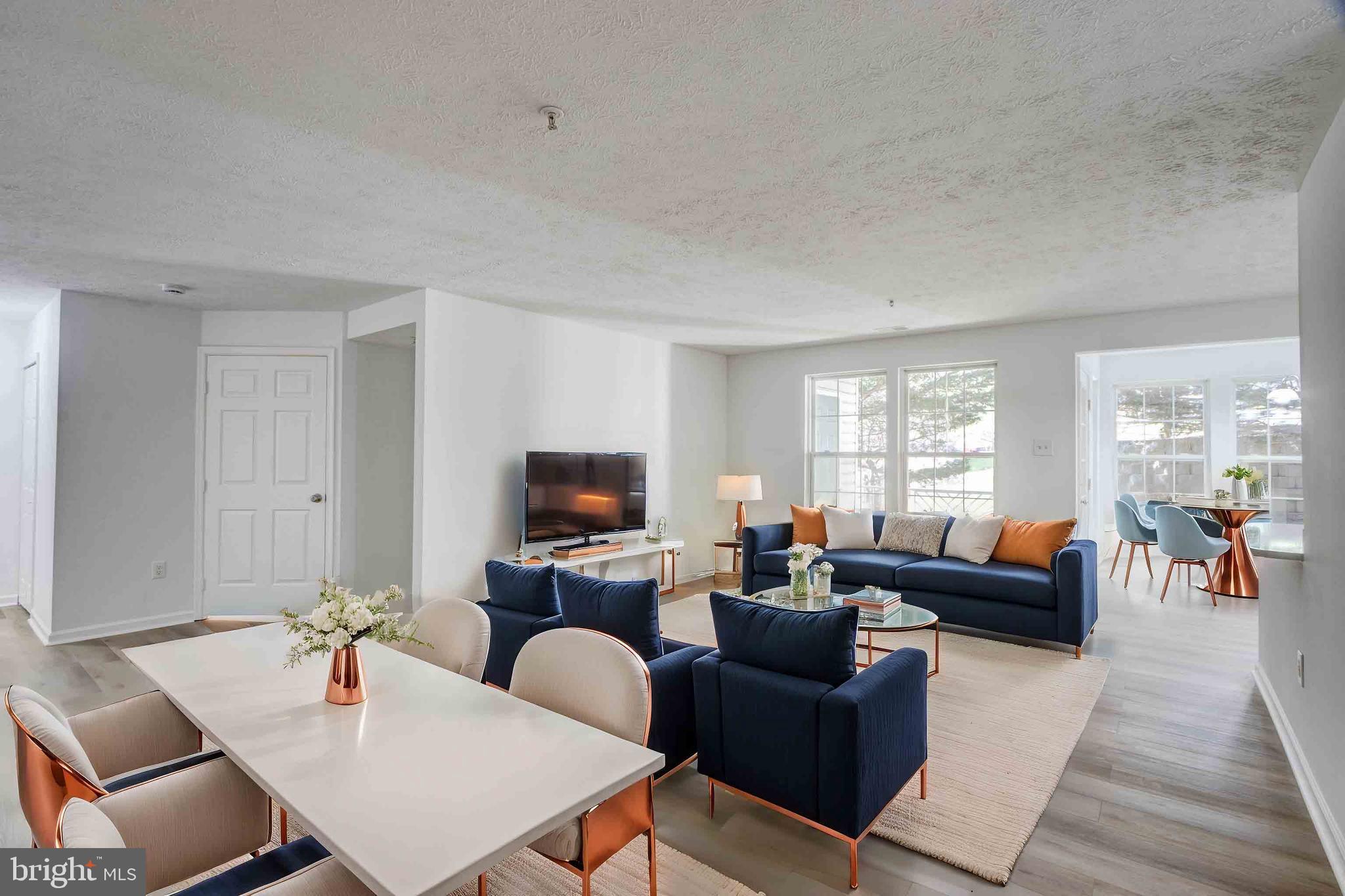 7903 Valley Manor Road, Unit 103 Owings Mills, MD 21117 - Photo 41 of 58 a living room with furniture a fireplace and a flat screen tv