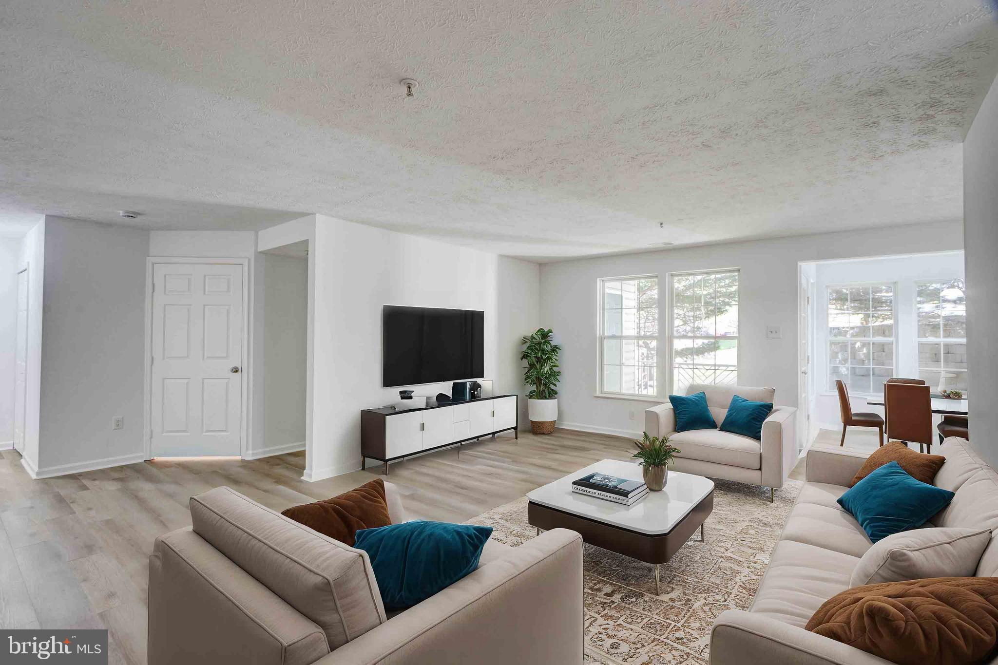 7903 Valley Manor Road, Unit 103 Owings Mills, MD 21117 - Photo 42 of 58 a living room with furniture and a flat screen tv