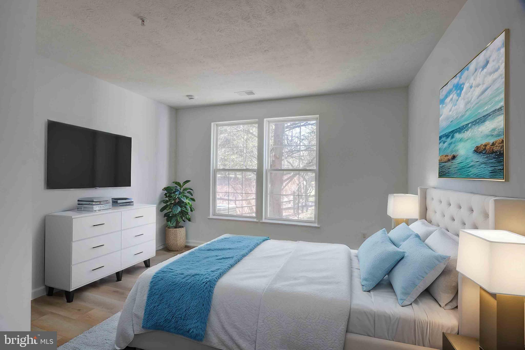 7903 Valley Manor Road, Unit 103 Owings Mills, MD 21117 - Photo 50 of 58 a bedroom with a bed and flat screen tv