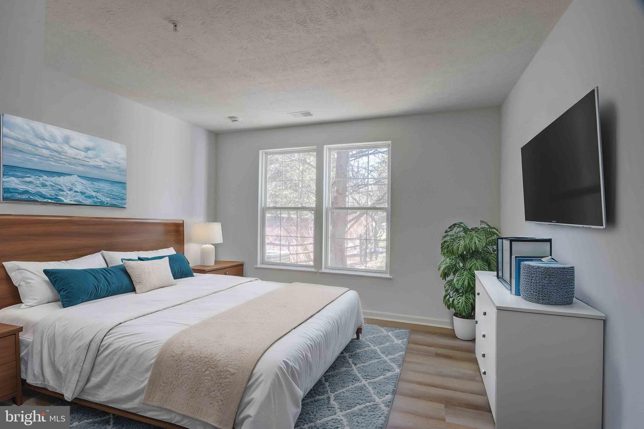 7903 Valley Manor Road, Unit 103 Owings Mills, MD 21117 - Photo 51 of 58 a bedroom with a large bed and a flat screen tv