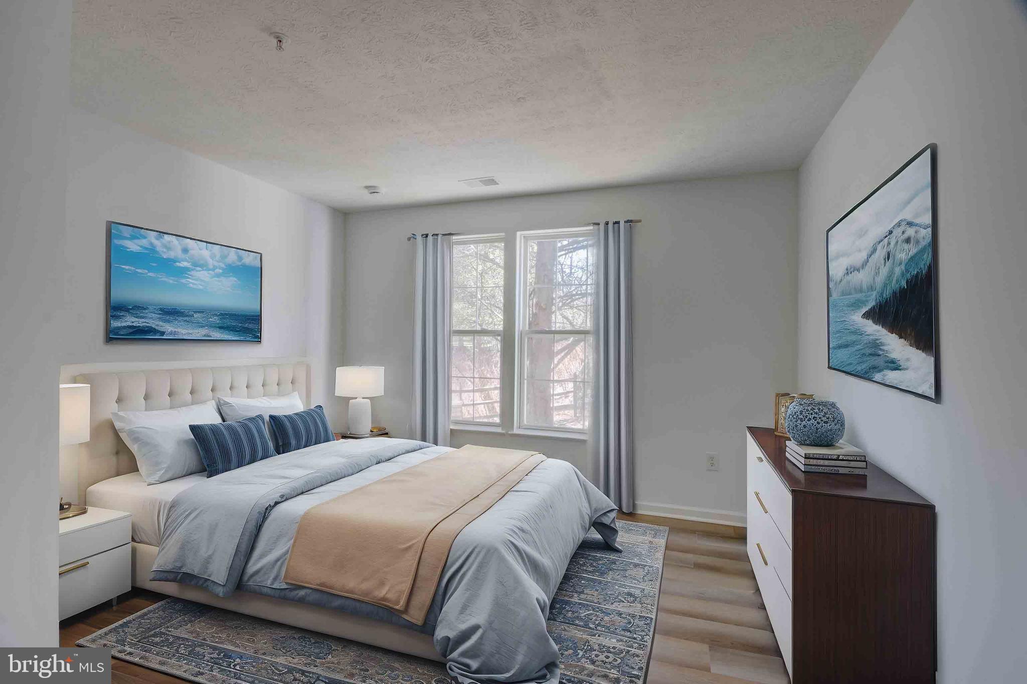 7903 Valley Manor Road, Unit 103 Owings Mills, MD 21117 - Photo 52 of 58 a bedroom with bed and wooden floor