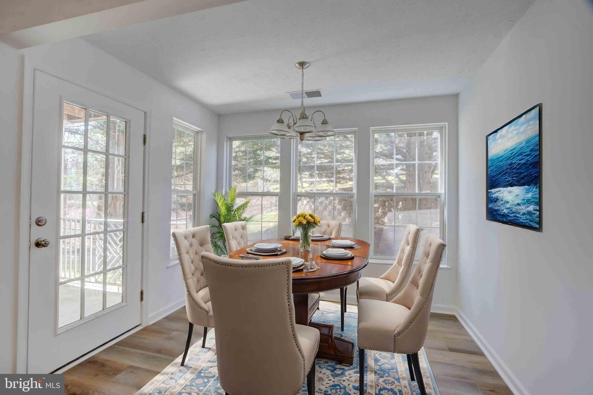 7903 Valley Manor Road, Unit 103 Owings Mills, MD 21117 - Photo 55 of 58 a dining room with furniture a chandelier and wooden floor