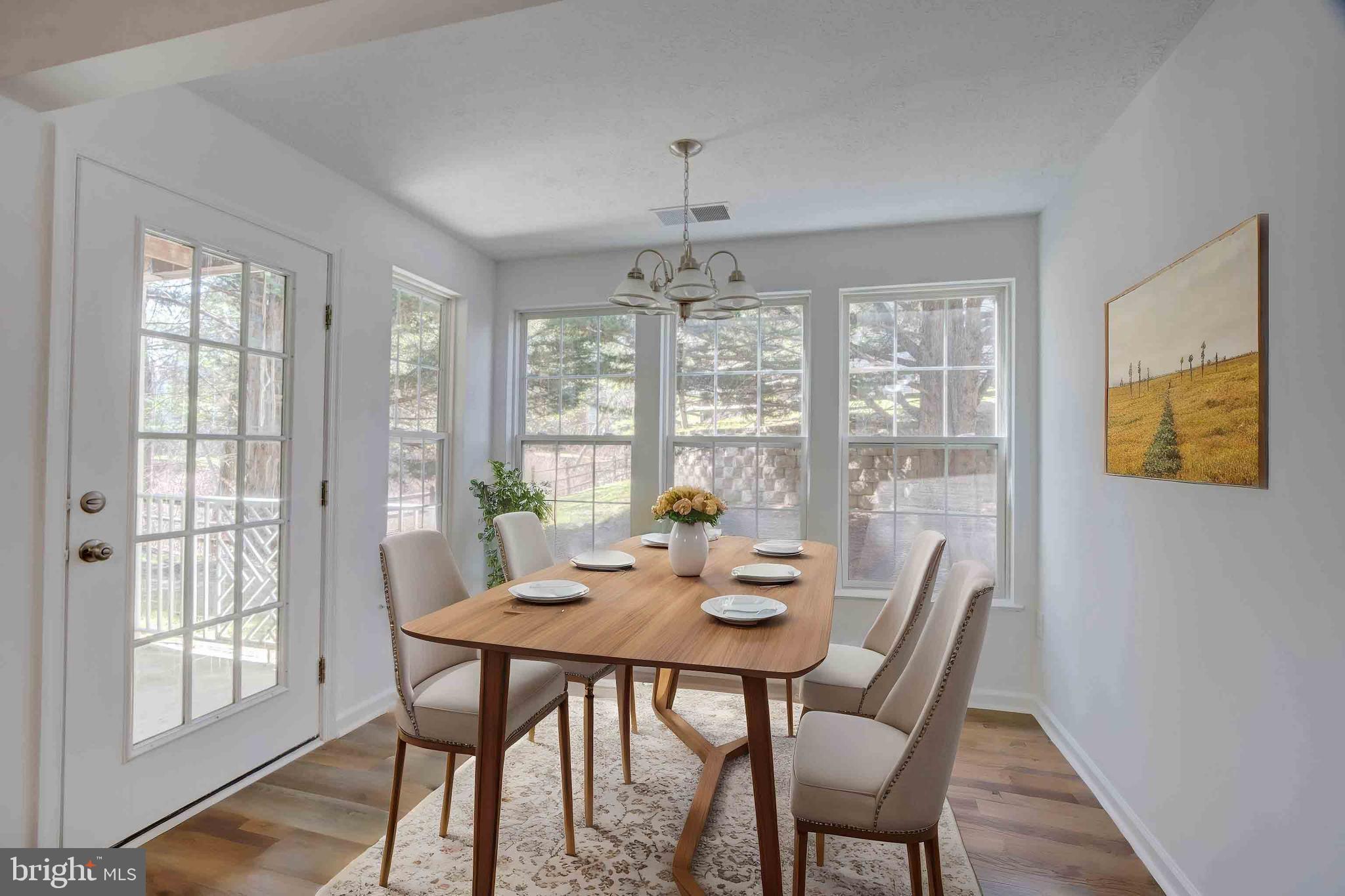 7903 Valley Manor Road, Unit 103 Owings Mills, MD 21117 - Photo 56 of 58 a view of a dining room with furniture large windows and wooden floor