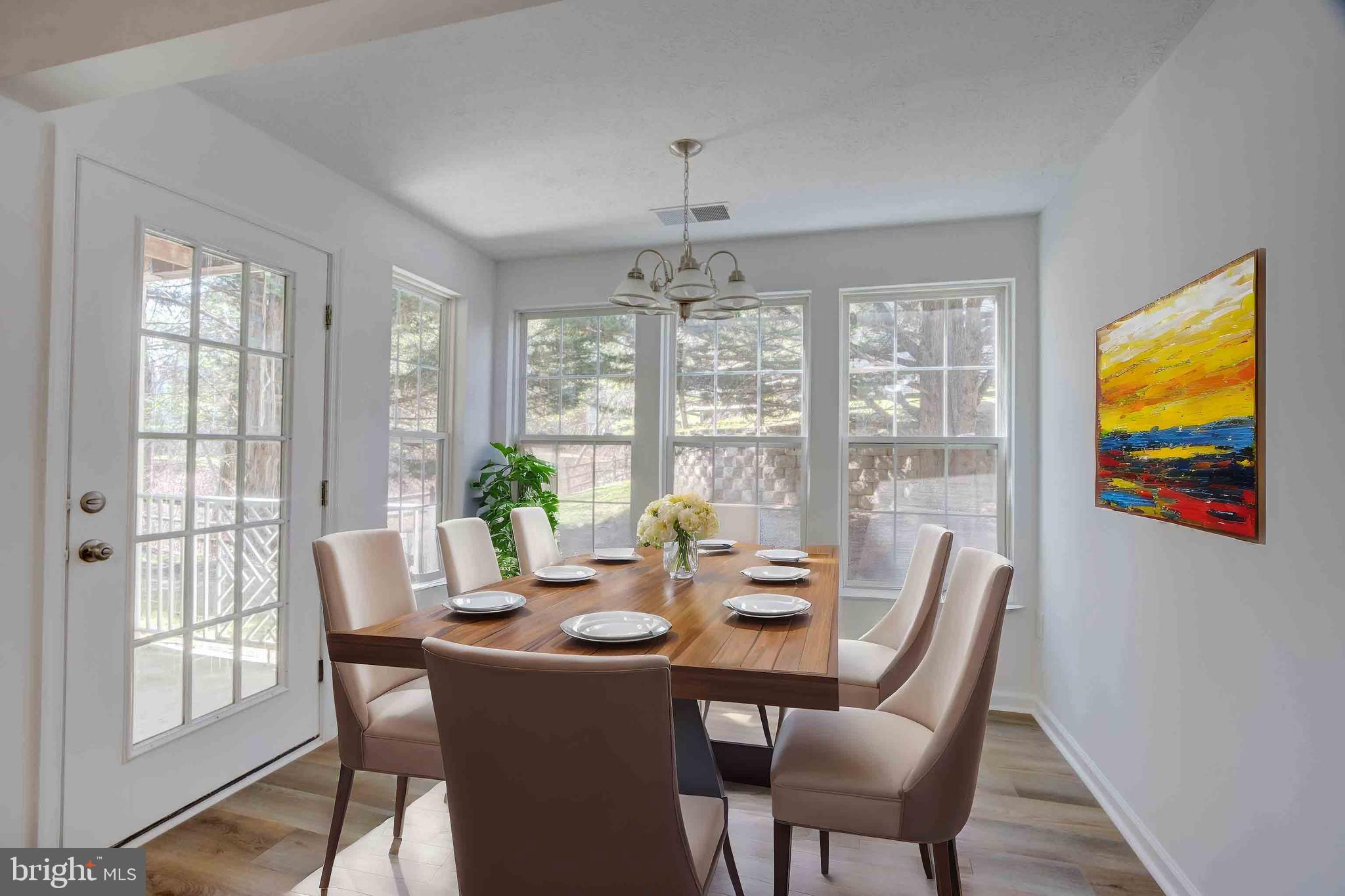 7903 Valley Manor Road, Unit 103 Owings Mills, MD 21117 - Photo 57 of 58 a view of a dining room with furniture large windows and wooden floor