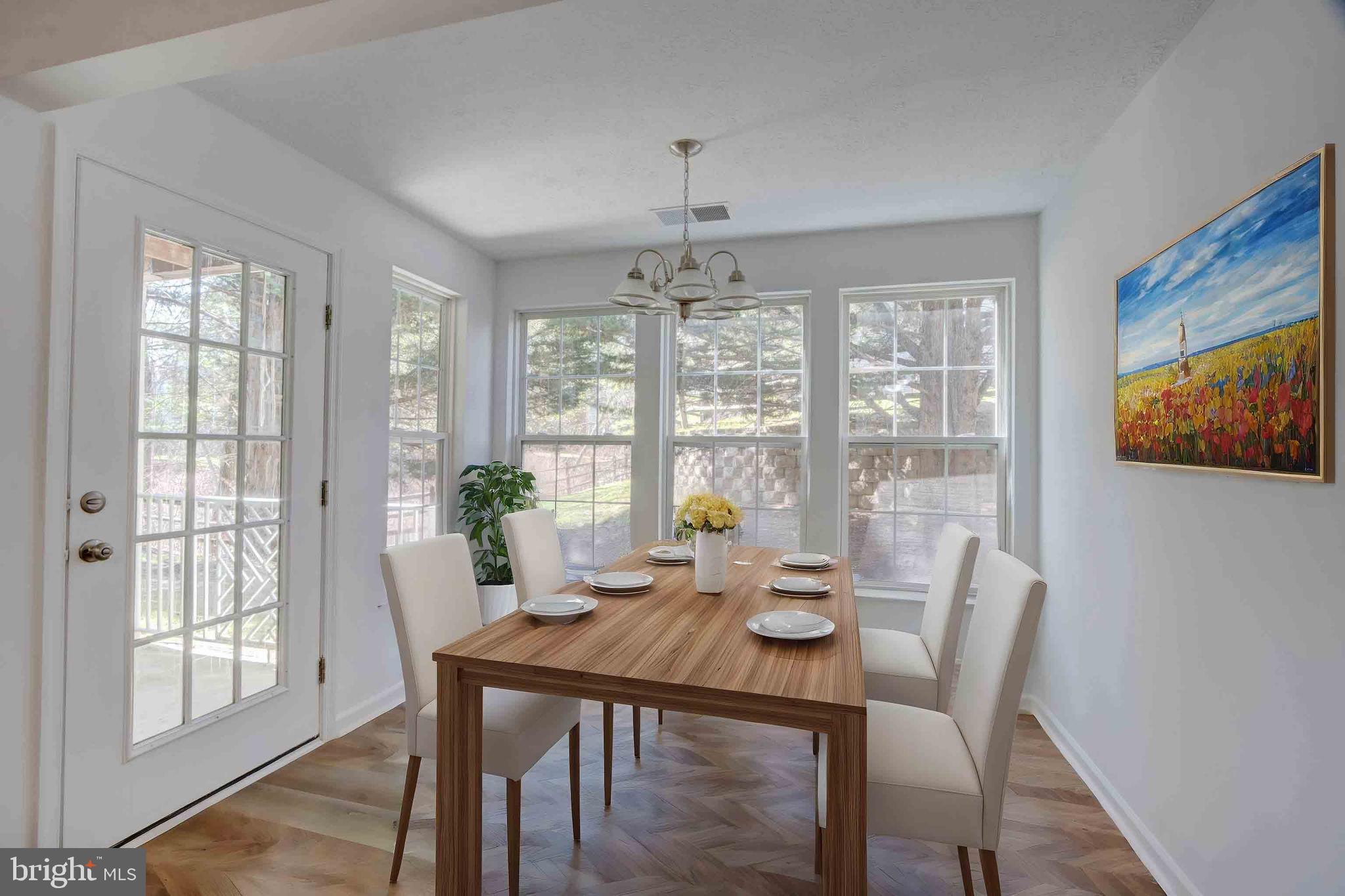 7903 Valley Manor Road, Unit 103 Owings Mills, MD 21117 - Photo 58 of 58 a view of a dining room with furniture large windows and wooden floor