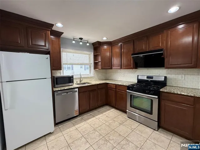 a kitchen with stainless steel appliances a stove sink microwave and cabinets