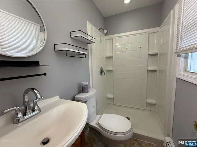 a bathroom with a toilet a sink and mirror