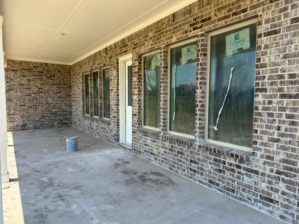 295 Brown Road Leonard, TX 75452 - Photo 22 of 26 Covered patio featuring a solid ceiling, brick exterior, multiple large windows, and a white exterior door
