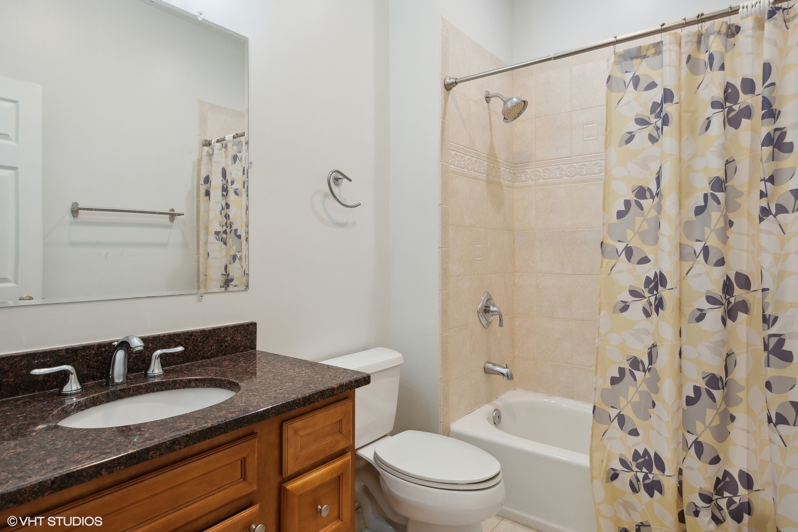4417 South Calumet Avenue, Unit 2S Chicago, IL 60653 - Photo 13 of 16 a bathroom with a granite countertop sink toilet a mirror a bathtub and shower