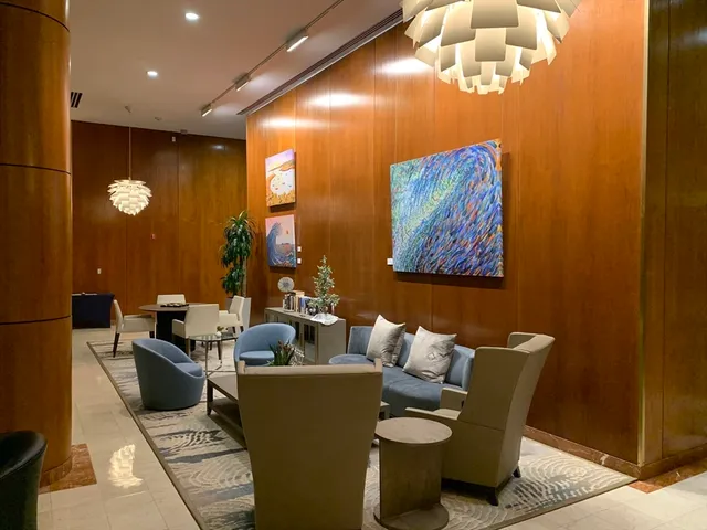 a living room with furniture a chandelier and a large window