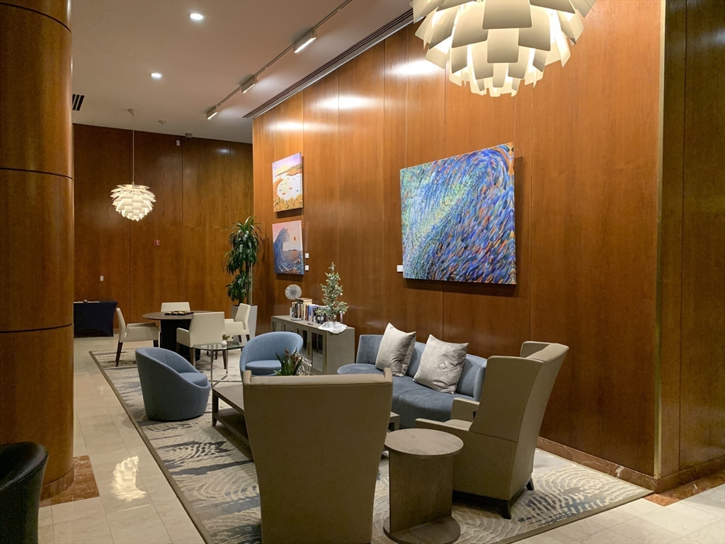 65 East India Row, Unit 22C Boston, MA 02110 - Photo 16 of 17 a living room with furniture a chandelier and a large window