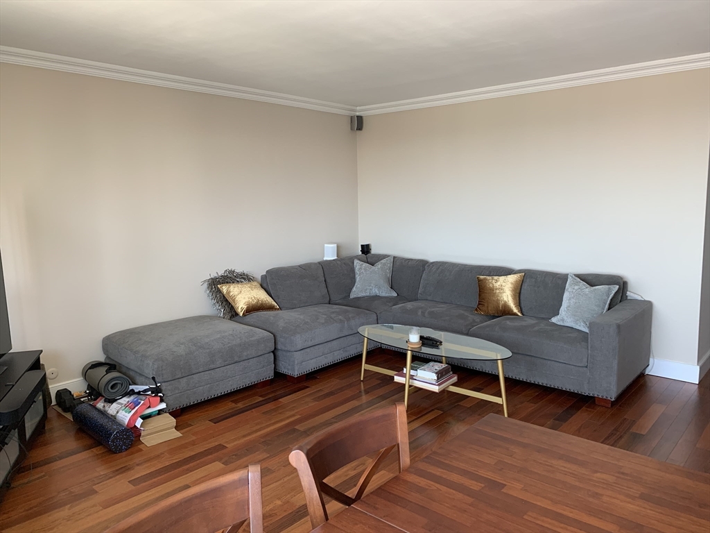 65 East India Row, Unit 22C Boston, MA 02110 - Photo 4 of 17 a living room with furniture and a wooden floor
