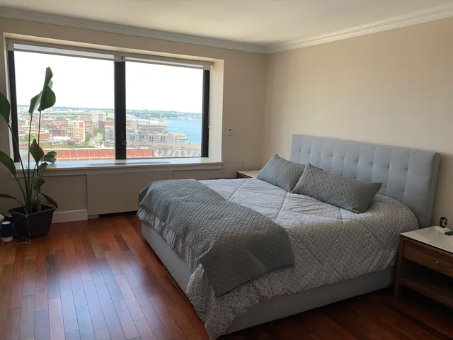 a bedroom with a bed and wooden floor