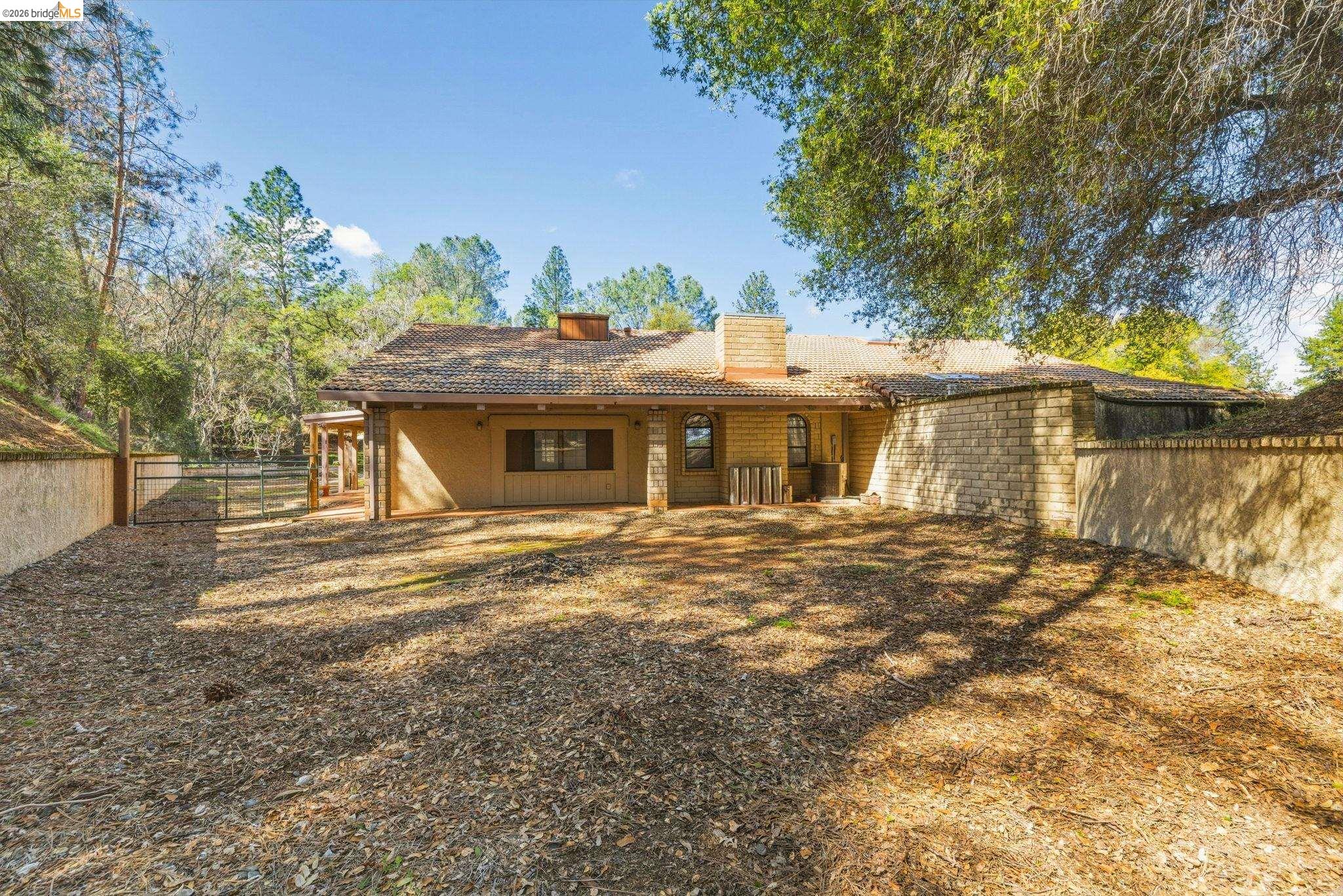 23608 Porcina Way Columbia, CA 95310 - Photo 47 of 51 Rear view of property featuring a fenced backyard, a chimney, and a tile roof