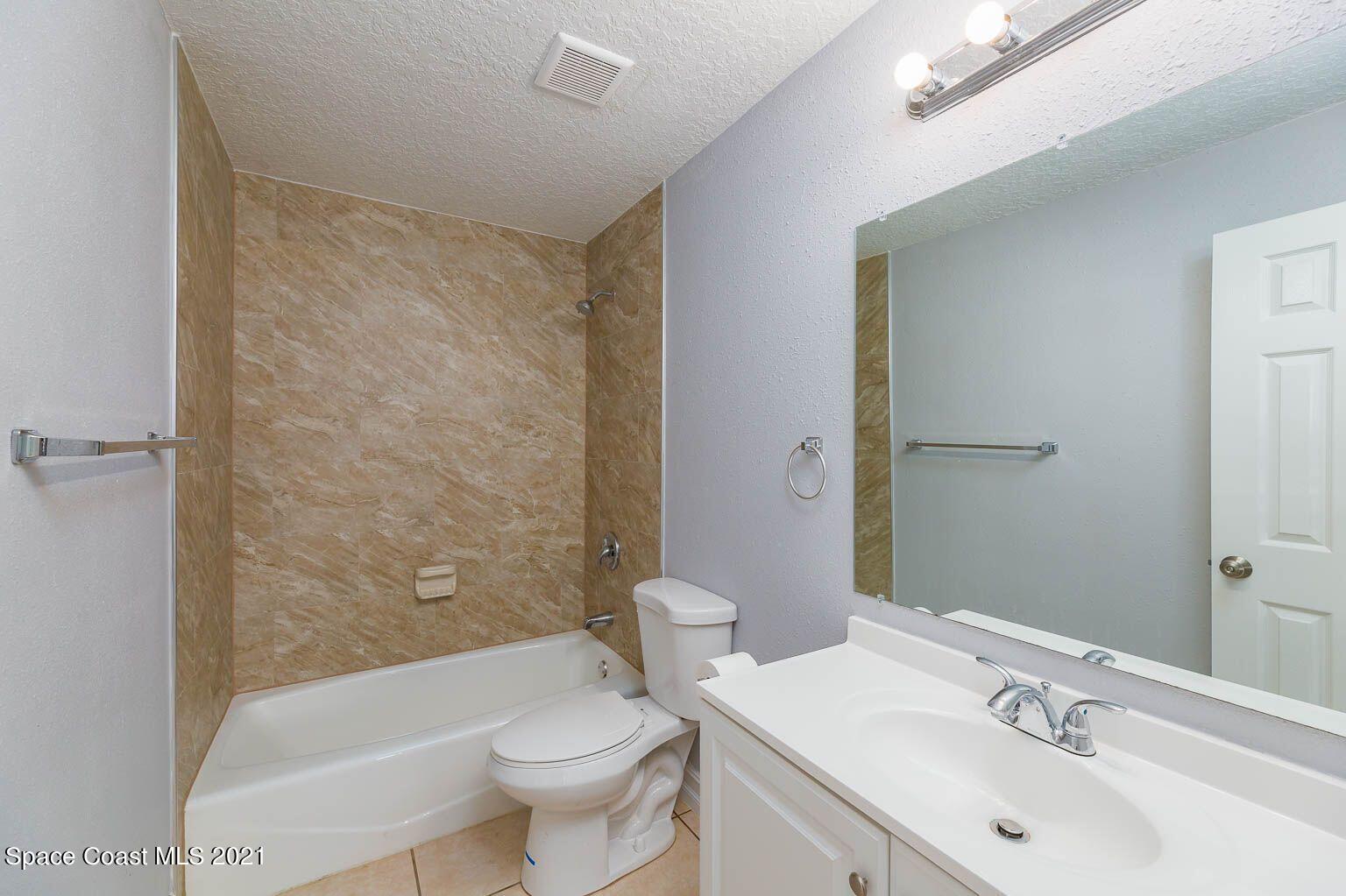 2648 Locksley Road Melbourne, FL 32935 - Photo 13 of 16 a bathroom with a sink a toilet and shower