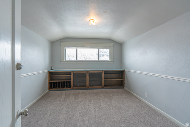 33 North 200 East Logan, UT 84321 - Photo 31 of 54 Unfurnished room with lofted ceiling, light colored carpet, and a textured ceiling