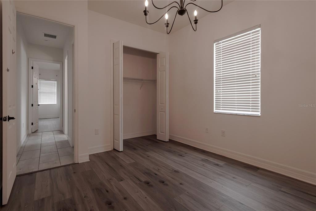 20315 Passagio Drive Venice, FL 34293 - Photo 17 of 40 a view of an empty room with wooden floor and a window