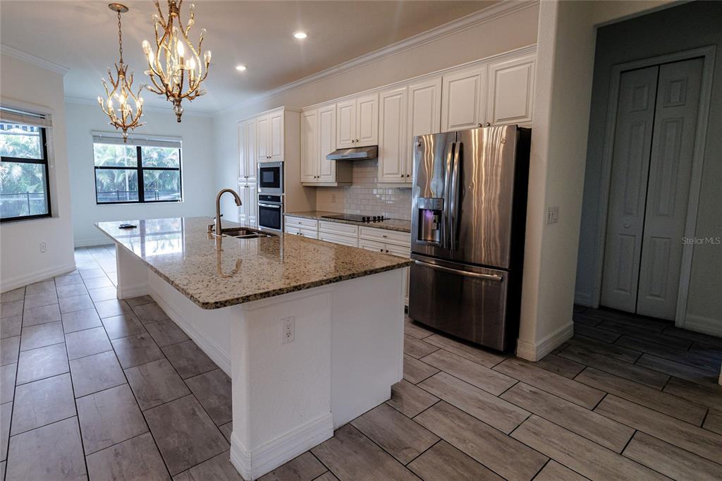 20315 Passagio Drive Venice, FL 34293 - Photo 7 of 40 a kitchen with stainless steel appliances granite countertop a refrigerator a sink a stove a microwave and island