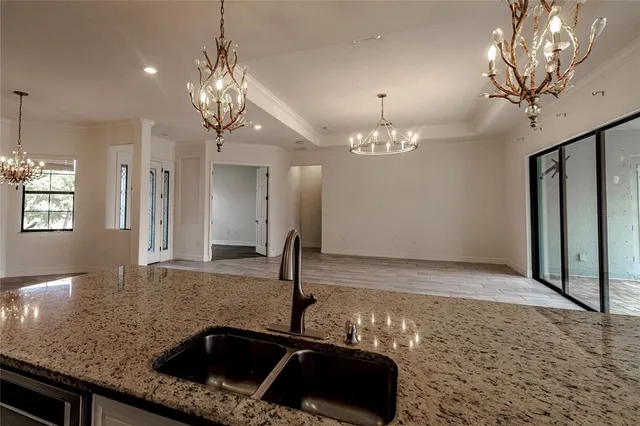 a view of a big room with chandelier and windows